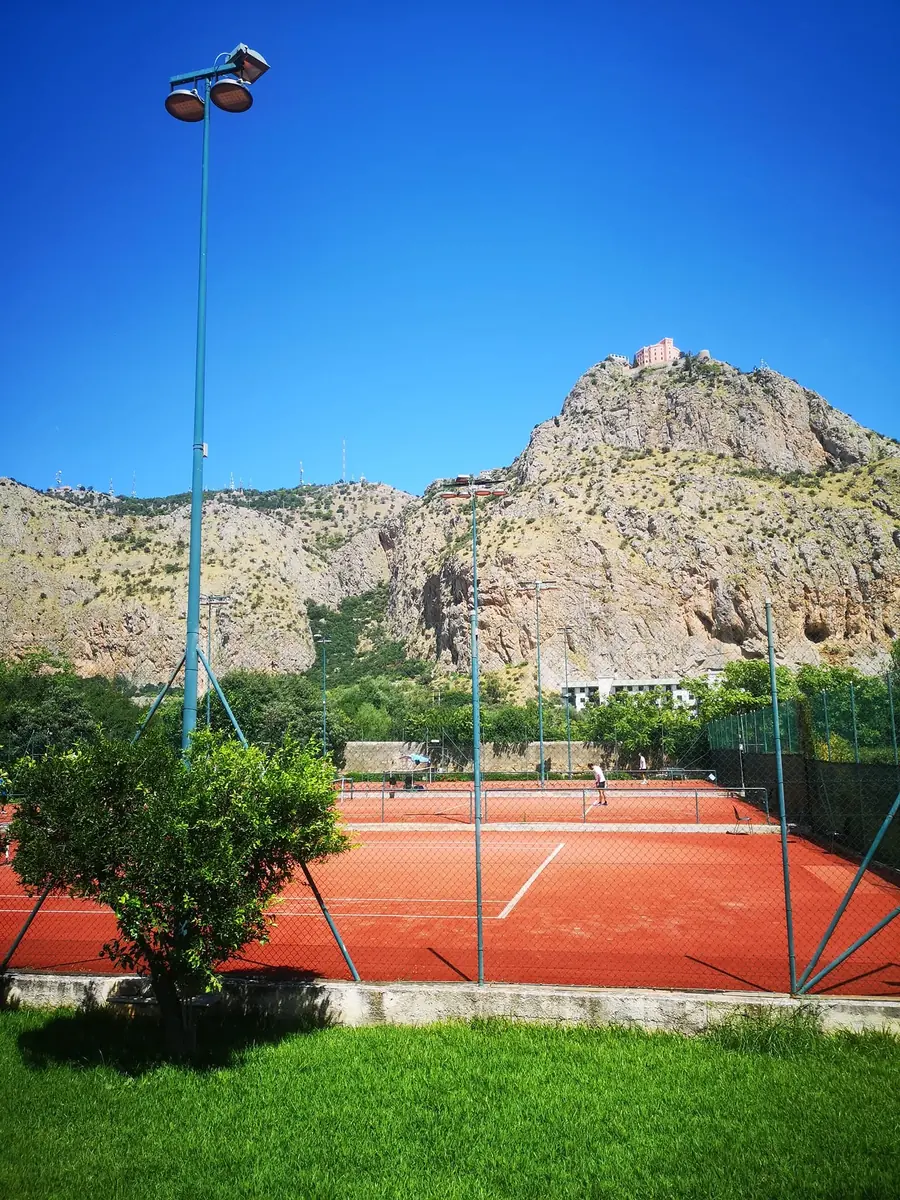 Campo in erba sintetica rossa del Mediterraneo Tennis Club con Monte Pellegrino sullo sfondo