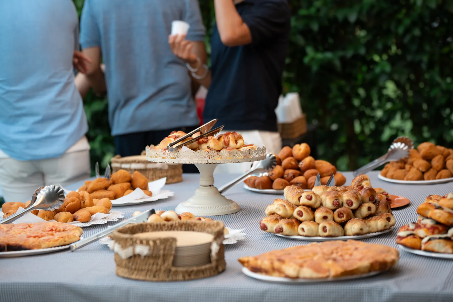 Buffet all'aperto con rustici e pizzette durante una festa al circolo