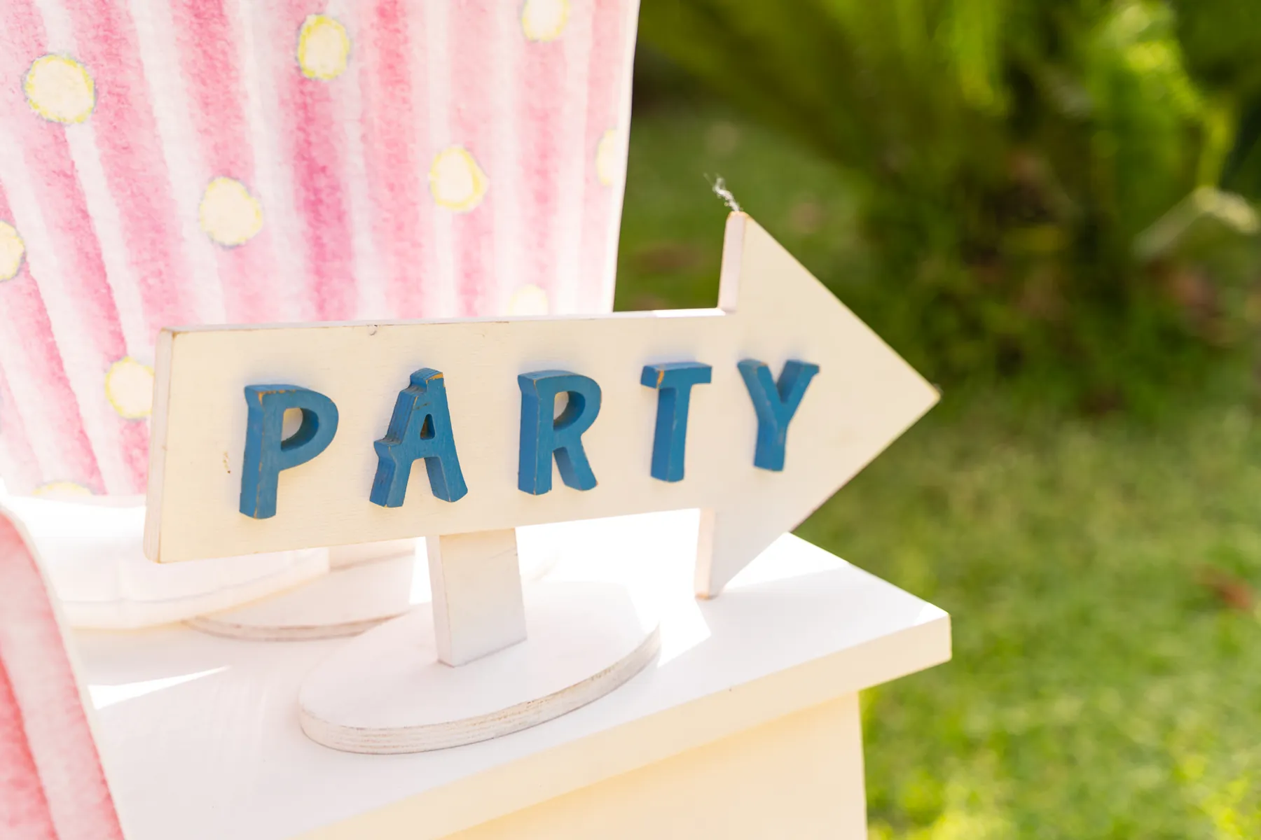 Cartello Party a forma di freccia su un tavolo decorato, nel giardino del circolo